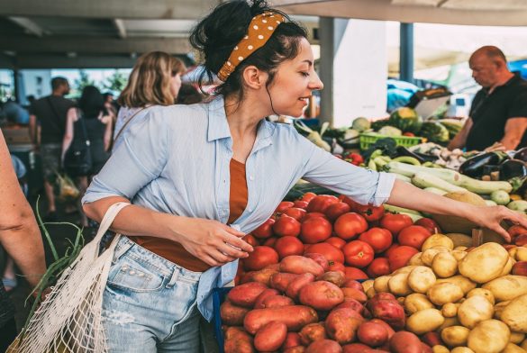 A Young Woman Buys Vegetables And Fruits At The Market .