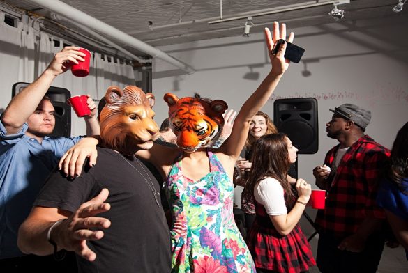 People Wearing Lion And Tiger Masks Dancing At Party