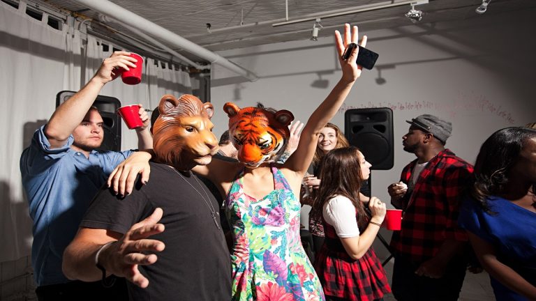 People Wearing Lion And Tiger Masks Dancing At Party